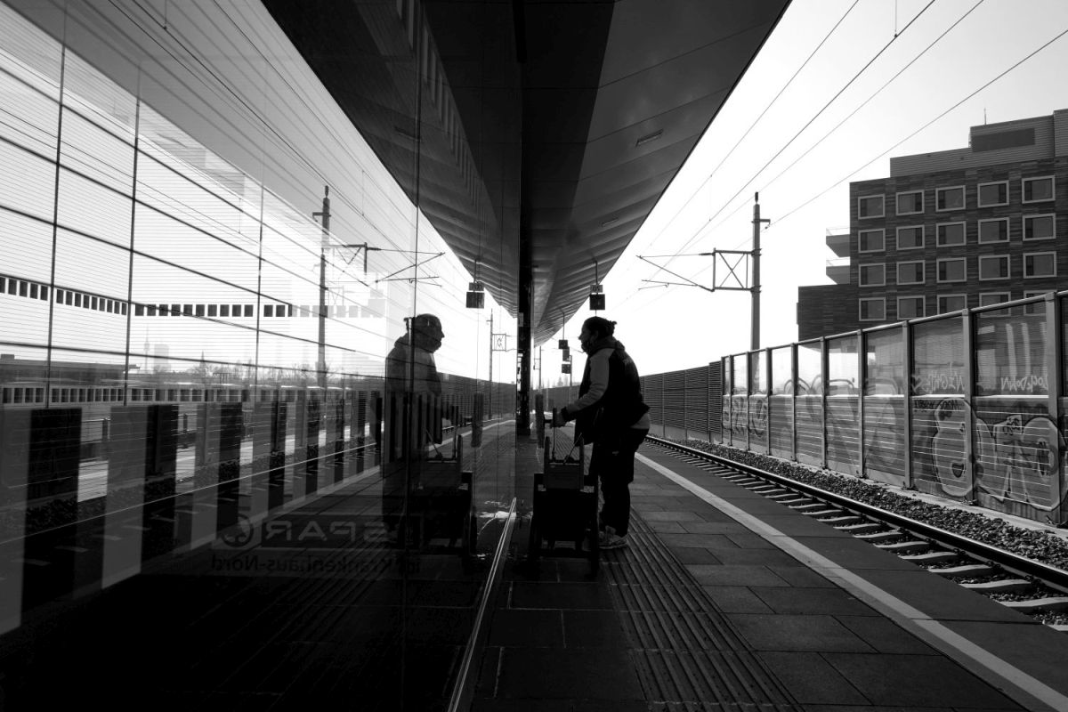 People in geometry of light and shadow at train stations